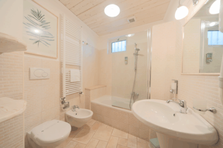 Bagno trullo Artemis, con vasca e doccia, lavandino, water e bidet.